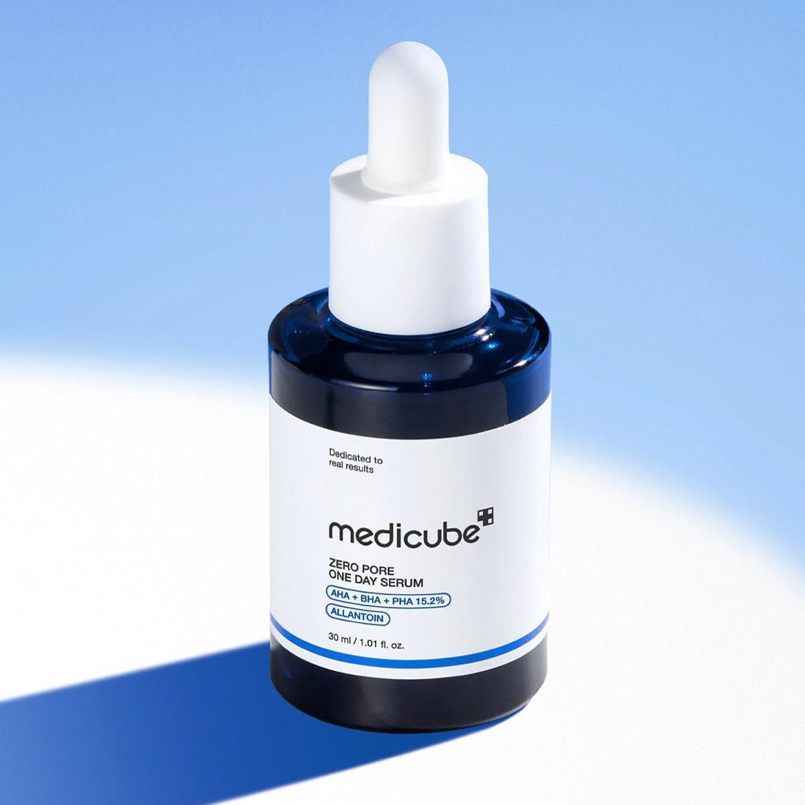 Close-up of MEDICUBE Zero Pore One-Day Serum 30ml against a blue background. Skincare product in white and blue packaging.