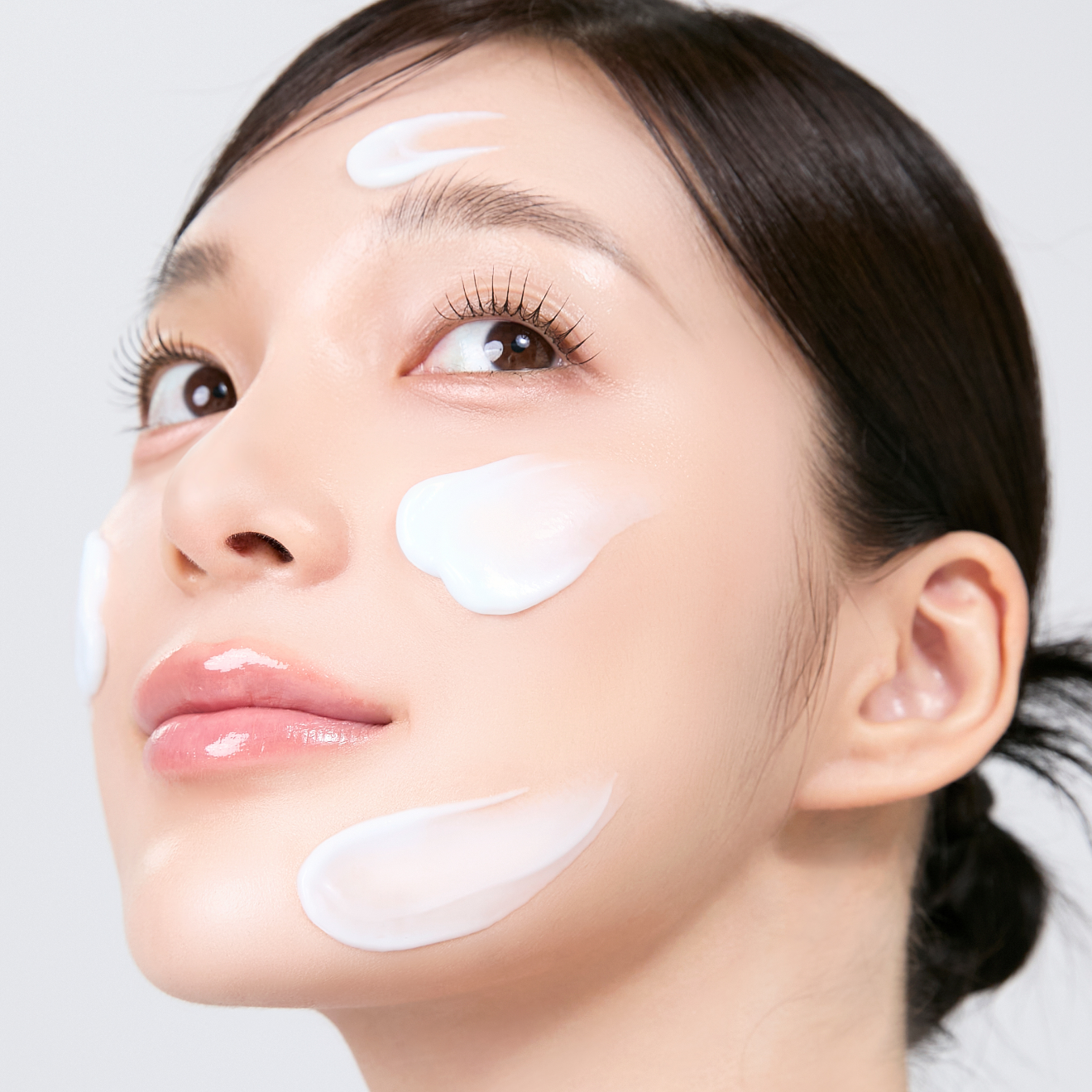 Woman applying MEDITHERAPY Squalane Skin Booster Moisturizer 150ml cream on face for healthy glow