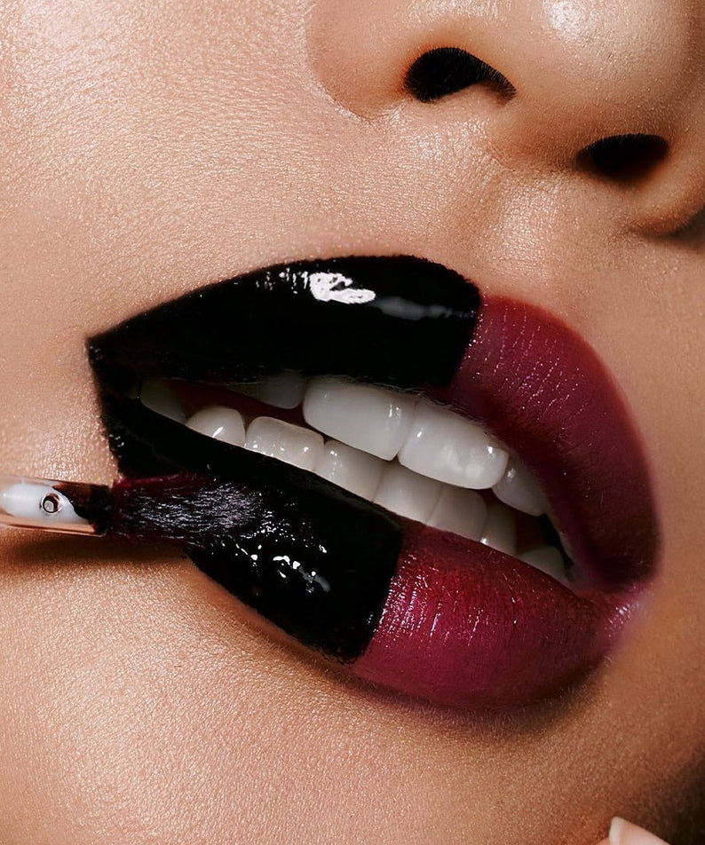 Close-up of person applying MILK TOUCH Black Peel-Off Lip Tattoo with brush, showcasing glossy texture and vivid color transformation.