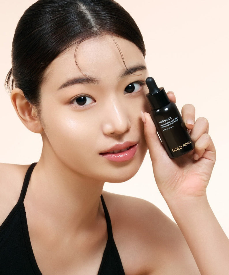 Woman holding MILK TOUCH Ginseng Gold PDRN Double Boosting Serum 30ml with radiant skin