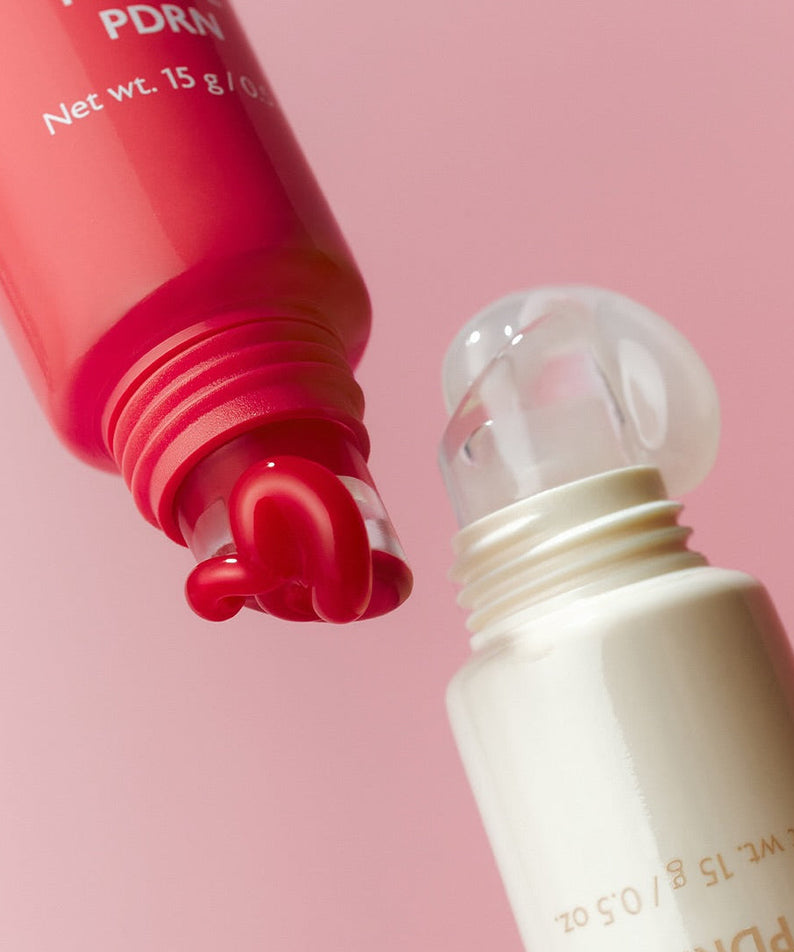 Close-up of MILK TOUCH Glow Up Collagen Lip Balm 15g with open tube showing balm texture and elegant design on pink background