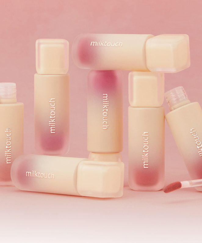 MILK TOUCH Spread Fit Blur Tint bottles arranged with applicators on a pink background.