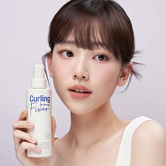 Woman holding MISE EN SCENE Curling Matte Volume Hair Fixer 200Ml, showcasing hair styling product.