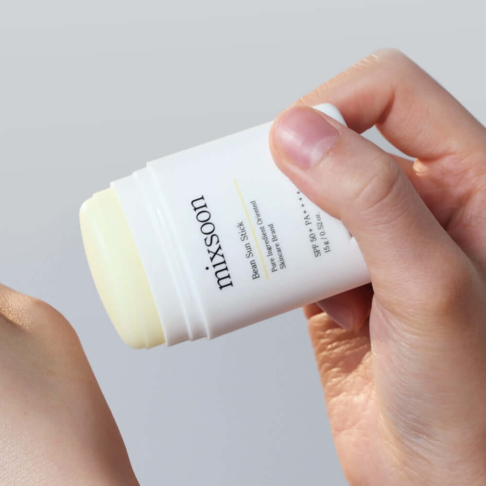 Hand applying MIXSOON Bean Sun Stick for sun protection and skincare