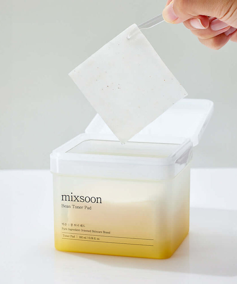 MIXSOON Bean Toner Pad being lifted from container, showcasing its texture.