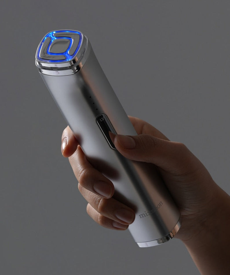 Hand holding MIXSOON Derma Booster Pro with LED light on, showcasing sleek design for skincare treatments.