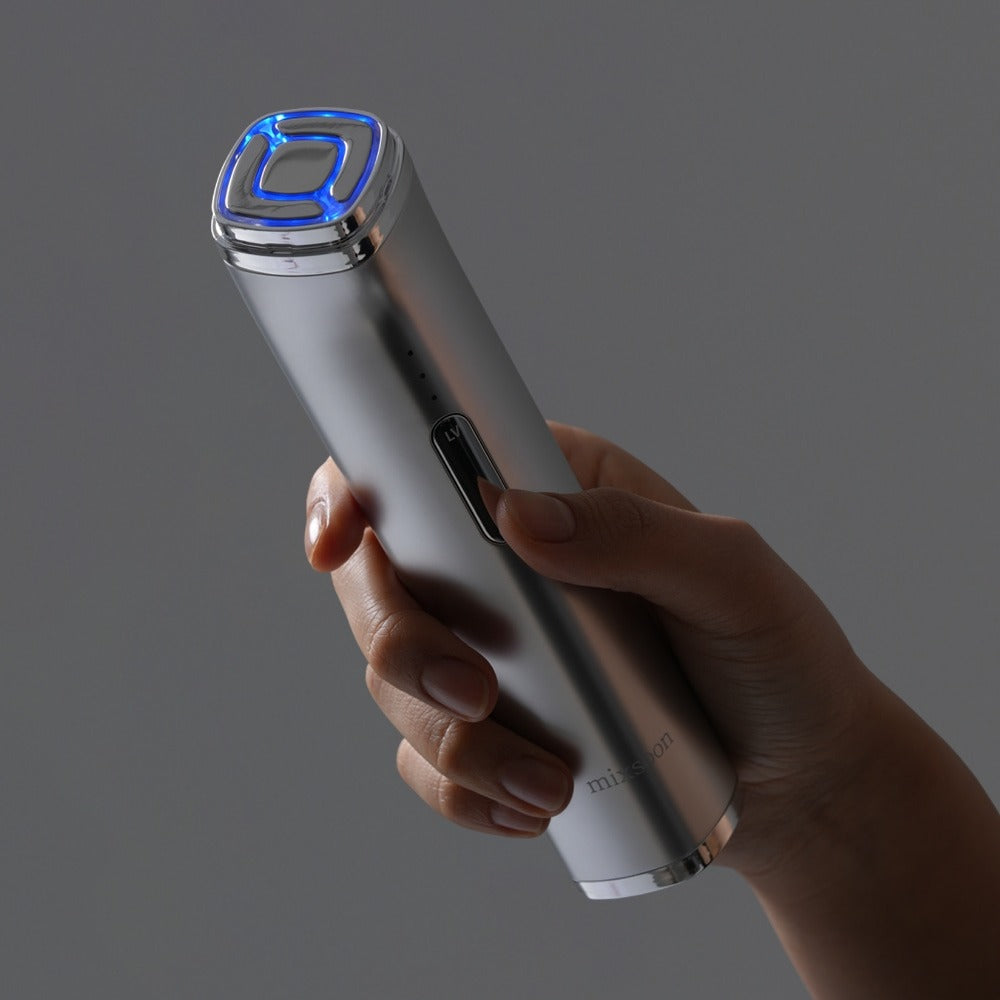 Hand holding MIXSOON Derma Booster Pro with LED light on, showcasing sleek design for skincare treatments.