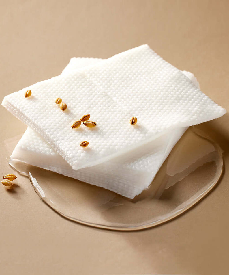 MIXSOON Galactomyces Toner Pad placed on a beige surface with grains and liquid