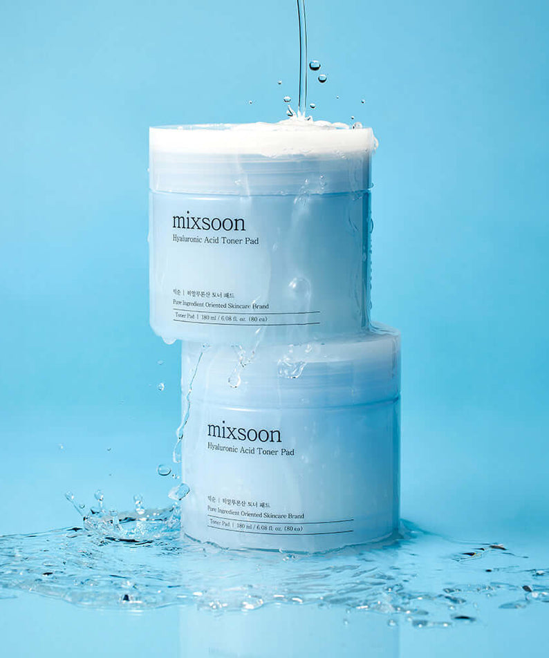 MIXSOON Hyaluronic Acid Toner Pad containers with water splashes on blue background
