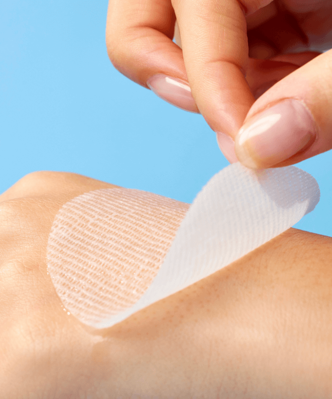 Close-up of a hand holding a MIXSOON Hyaluronic Acid Toner Pad being applied on skin, demonstrating its texture and application.