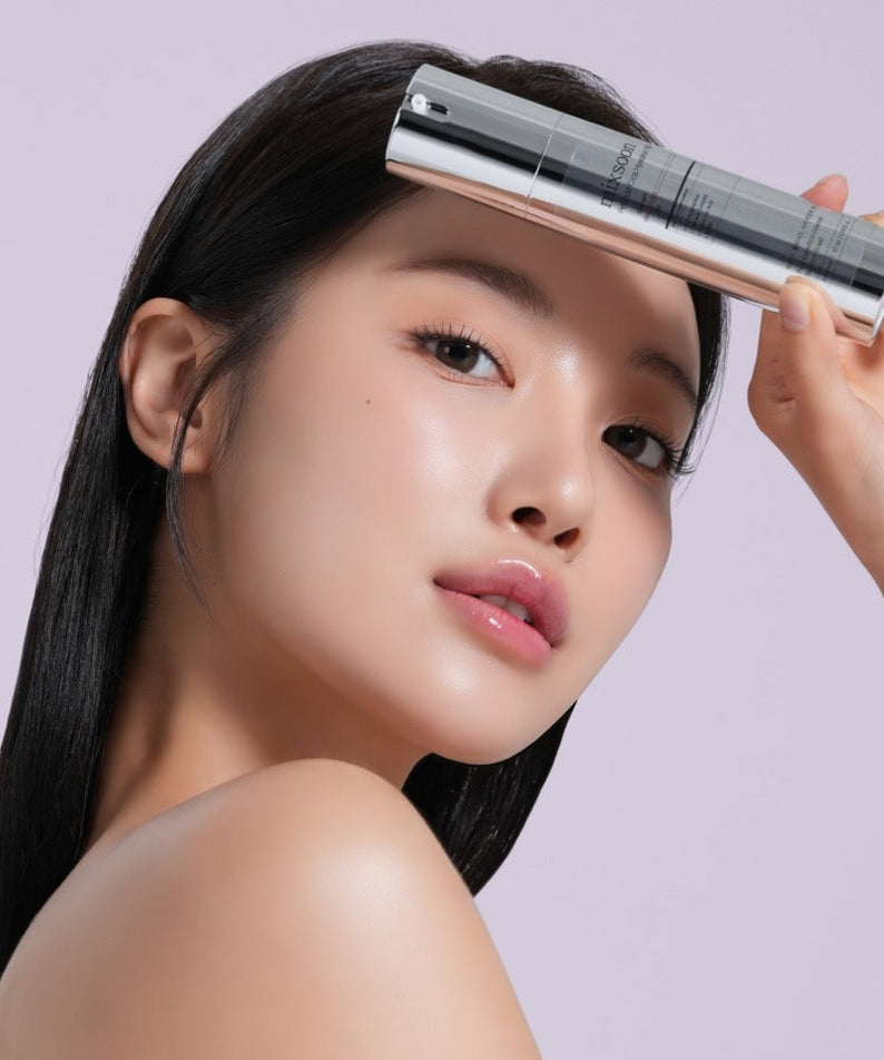 Woman holding MIXSOON Peptide Cica Hyal Shot 150 50ml next to her face on a light background