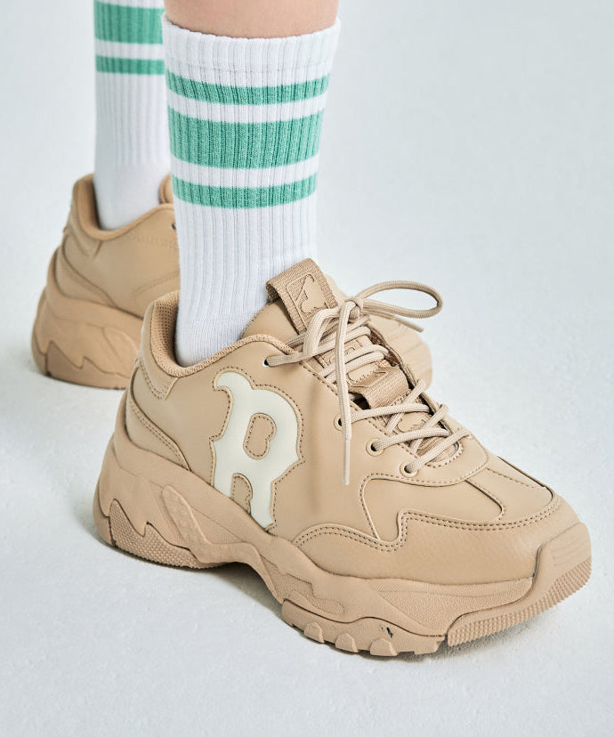 Person wearing MLB Bigball CHUNKY Window BOSTON RED SOX sneakers with green-striped socks on a white background