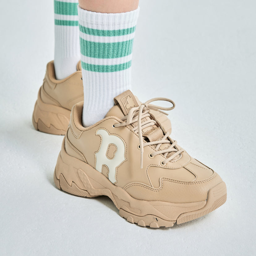 Person wearing MLB Bigball CHUNKY Window BOSTON RED SOX sneakers with green-striped socks on a white background