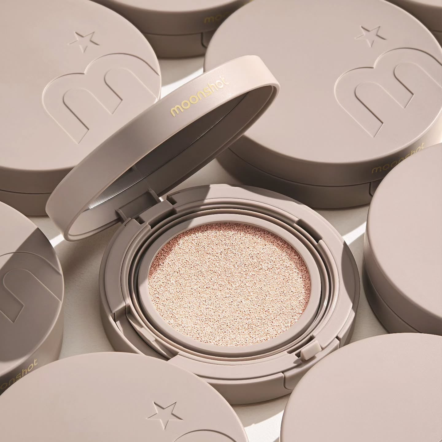 MOONSHOT Conscious Fit Cushion Foundation in open compact with soft beige lid, highlighting smooth cushion texture and sleek design.