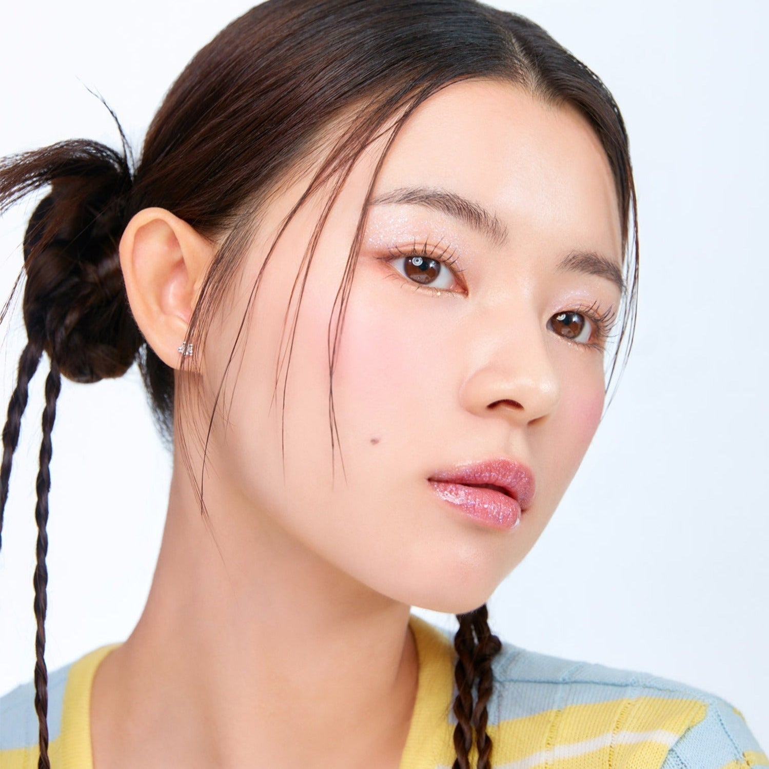 Model showcasing MOONSHOT Melting Mood Lip & Cheek in natural light, highlighting smooth texture and vibrant color on lips and cheeks.