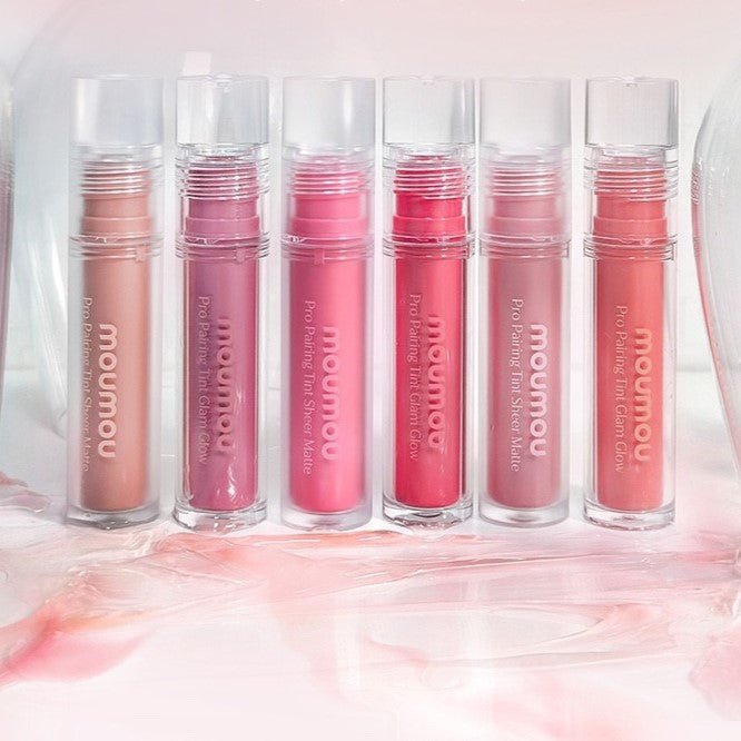 MOUMOU Pro Pairing Tint lip products in various shades displayed on a glass surface, highlighting the color options and sleek packaging.