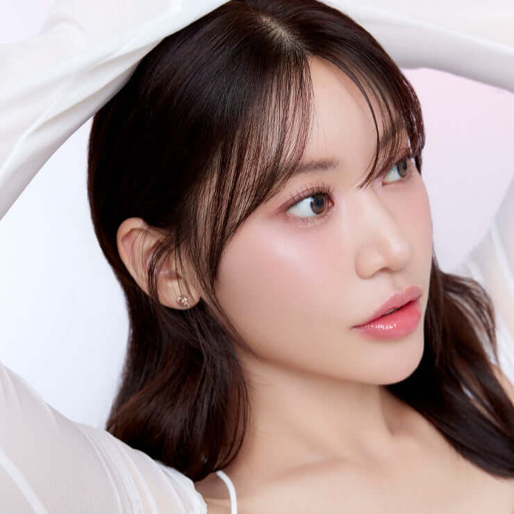 Model wearing makeup using MUDE Full Bloom Glow Palette enhancing natural beauty.