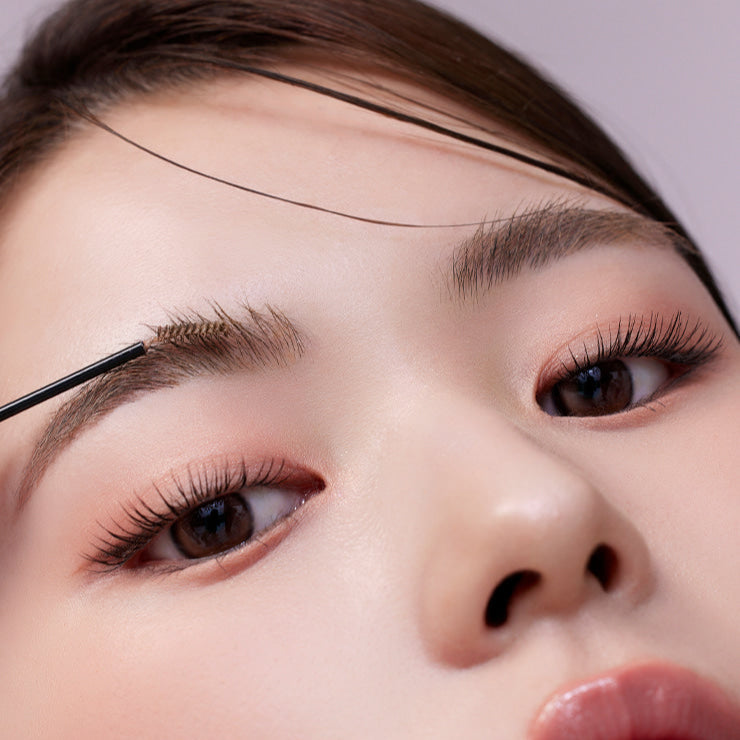 Close-up of a woman applying MUDE Inspire Skinny Brow Cara to her eyebrows for a natural look.