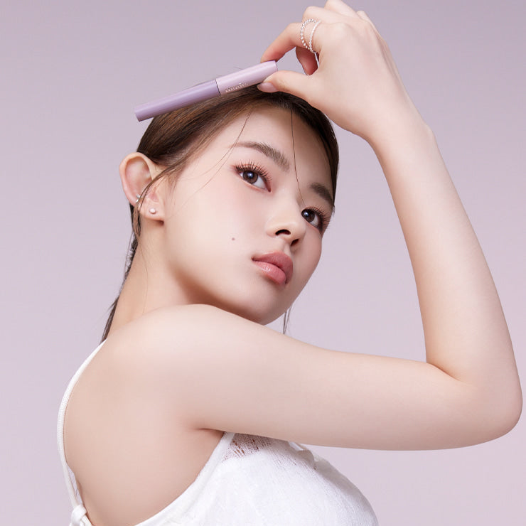 Woman applying MUDE Inspire Skinny Brow Cara for defined eyebrows