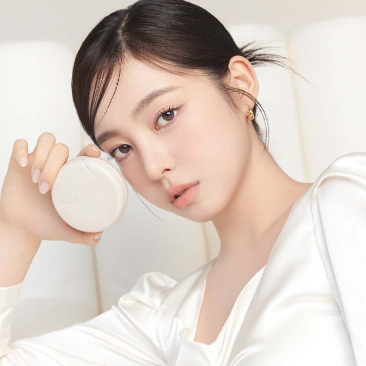 Person holding MUDE Soft Silky Fit Cushion in an elegant setting, showcasing the product's sleek design.