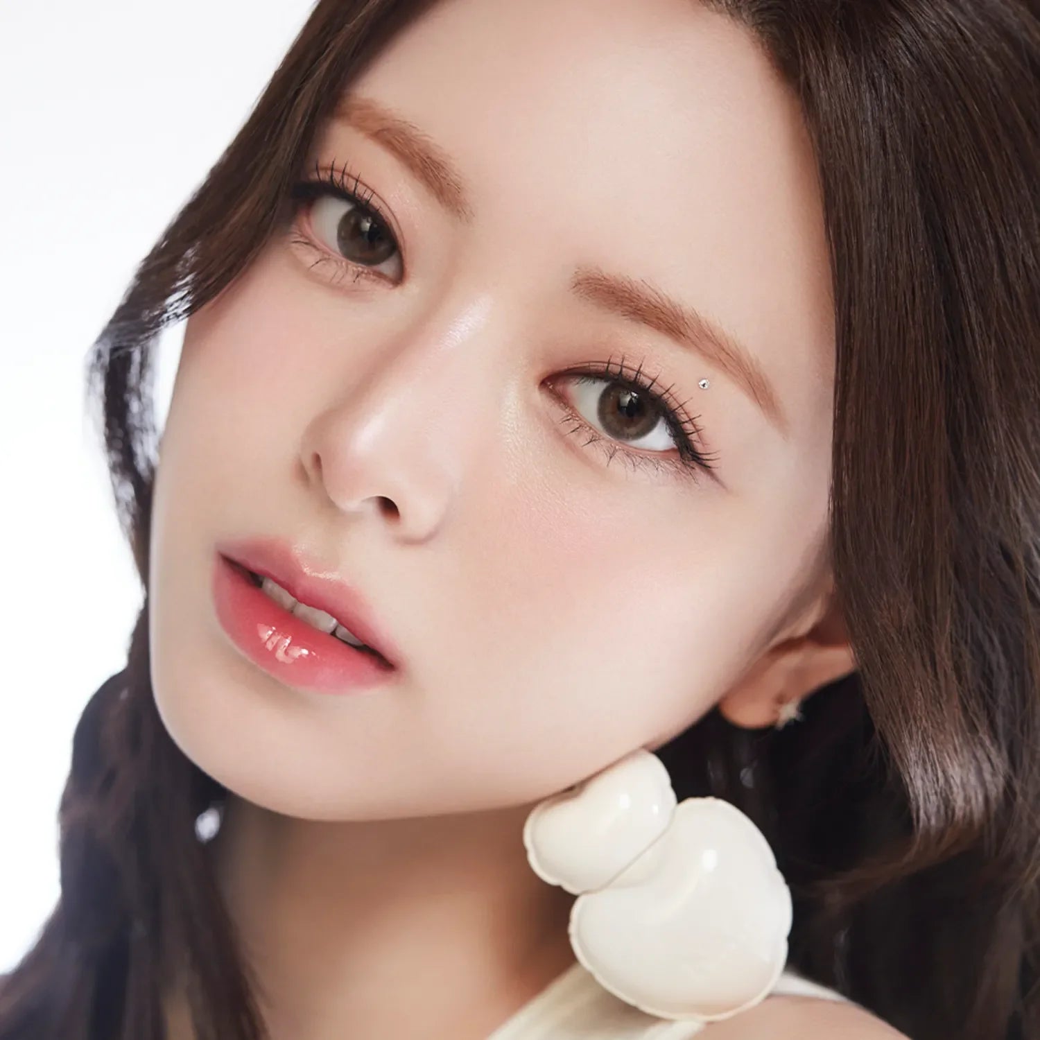 Model wearing NAMING Glow Heart Lip Tint with glossy lip finish.