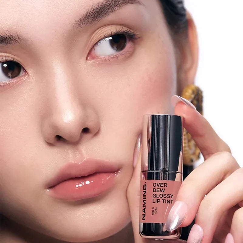 Close-up of a person holding NAMING Overdew Glossy Lip Tint, showcasing a glossy natural lip tint shade for a radiant look.