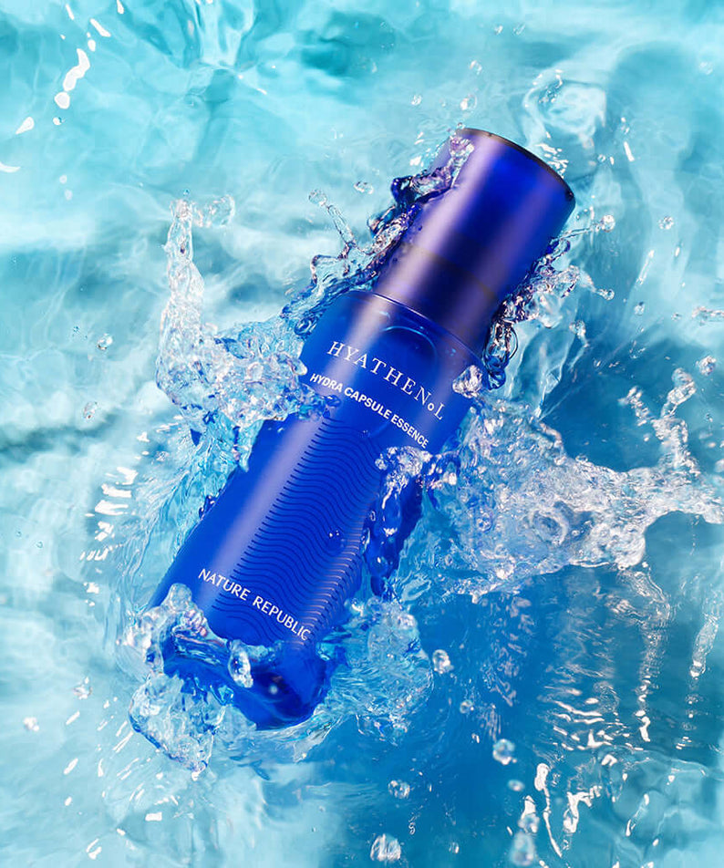 NATURE REPUBLIC Hyathenol Hydra Capsule Essence 50ml in blue bottle floating in water with splashes, highlighting skincare hydration