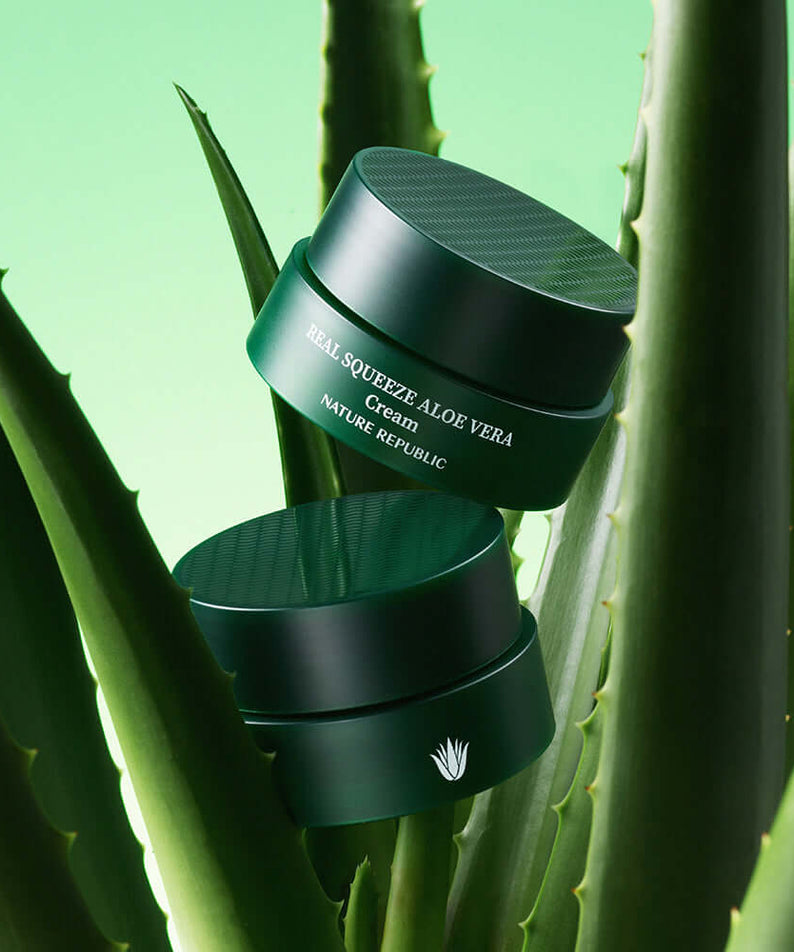 NATURE REPUBLIC Real Squeeze Aloe Vera Cream 55ml on aloe leaves, green background