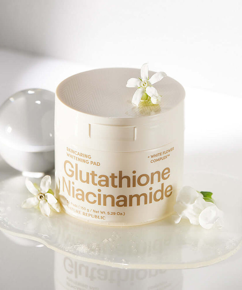NATURE REPUBLIC Skincaring Whitening Pads 150g displayed with flowers on a white surface, highlighting Glutathione and Niacinamide ingredients.