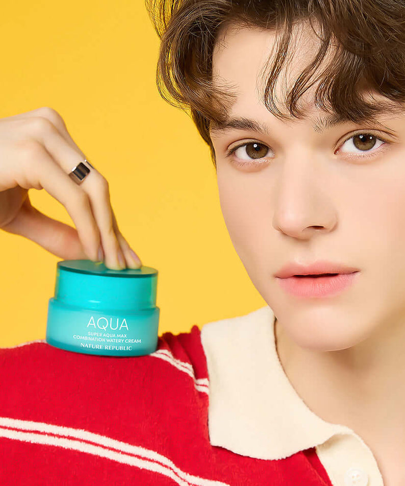Person holding NATURE REPUBLIC Super Aqua Max Combination Moisture Cream 80ml with yellow background.