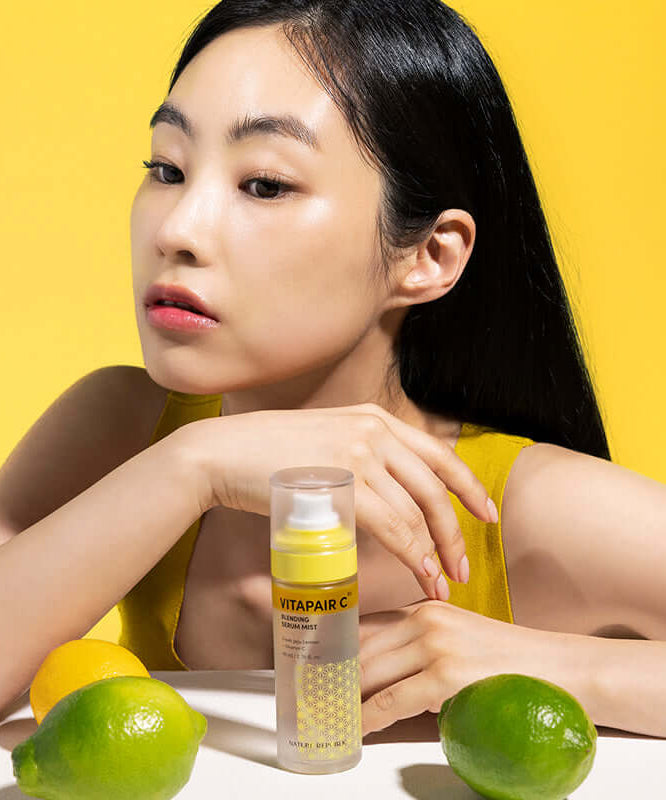 Woman with NATURE REPUBLIC Vitapair C Blending Serum Mist 80ml and citrus fruits