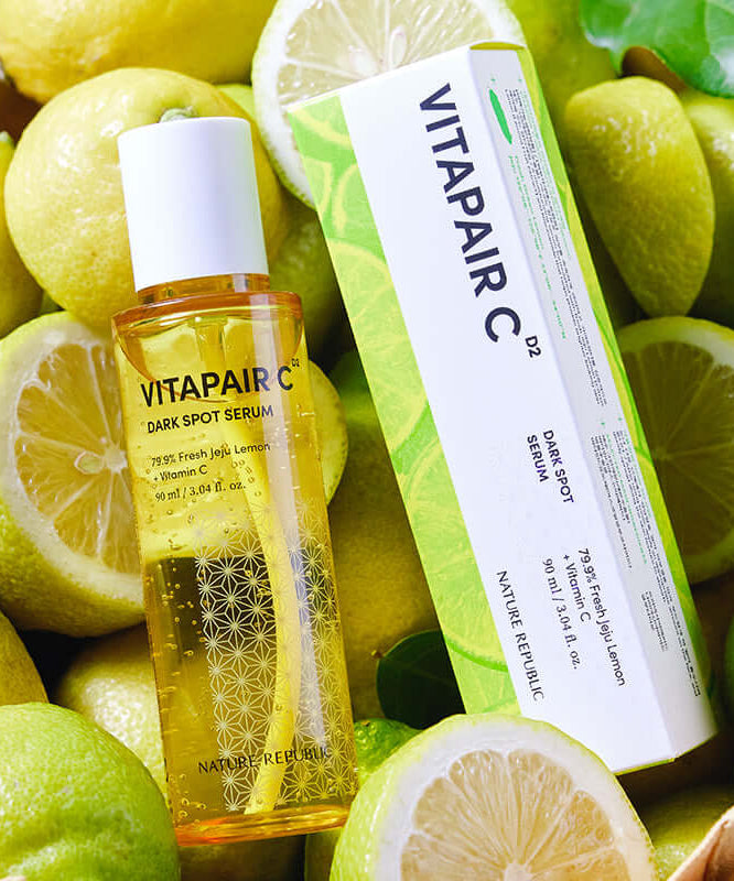 NATURE REPUBLIC Vitapair C Spot Serum 90ml Large Capacity 90ml bottle and box surrounded by fresh lemons.