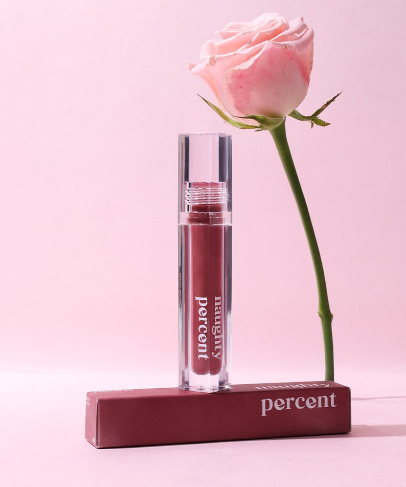 NAUGHTY PERCENT Matte Bloom Tint with rose on a pink background.