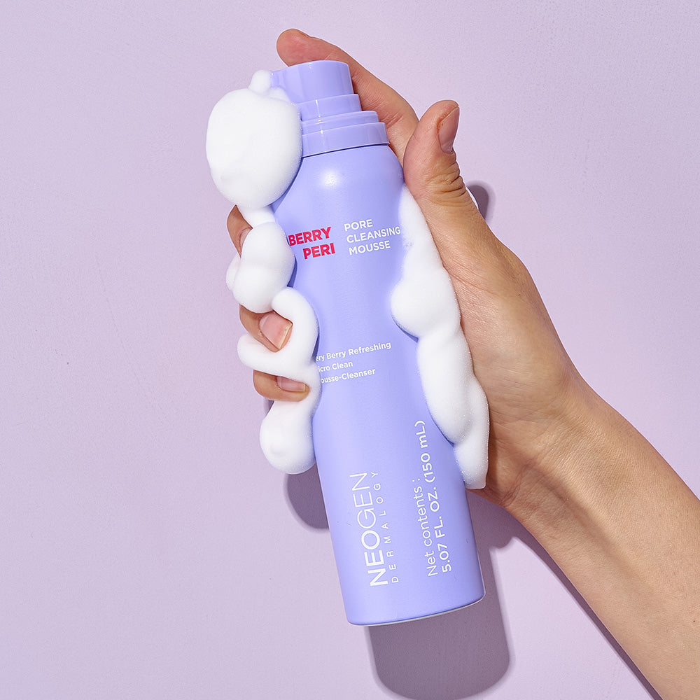 Hand holding NEOGEN Berry Peri Pore Cleansing Mousse 150ml with foam, showcasing the product's texture and packaging.