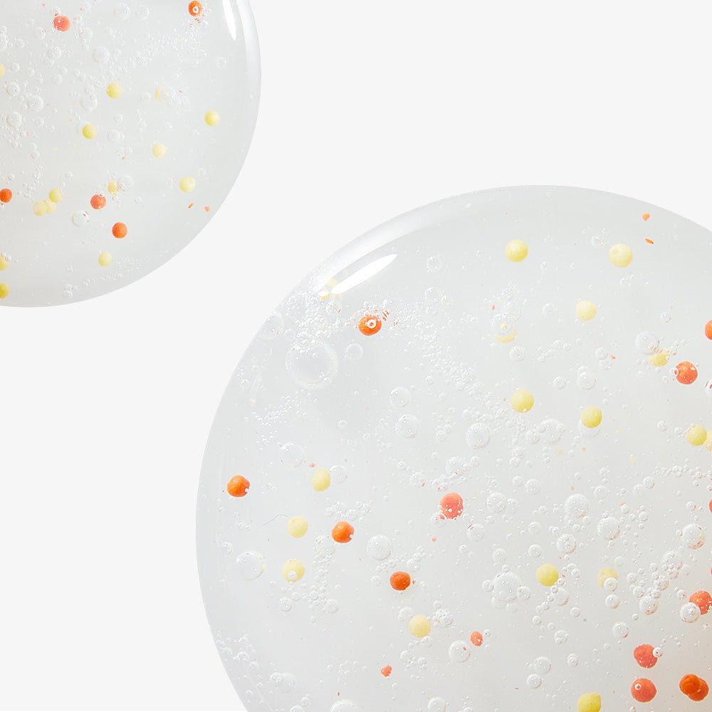 Close-up of NEOGEN Dounble Viita Capsual Cleansing Foam 150ml texture with vibrant orange and yellow capsules on a white background.