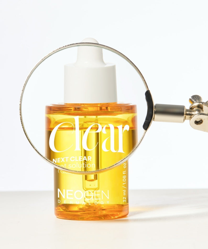 NEOGEN Next Clear Spot Solution 32ml with magnifying glass highlighting product details.