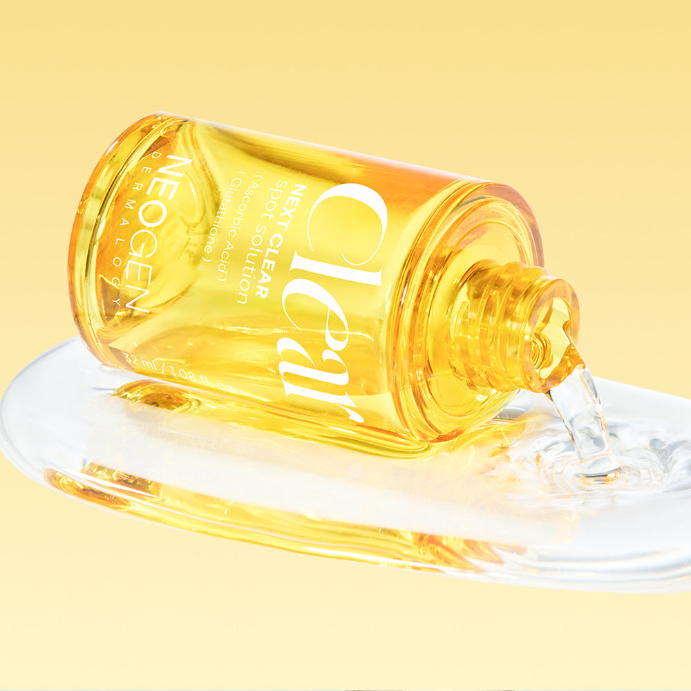NEOGEN Next Clear Spot Solution 32ml bottle spilling on surface against yellow background