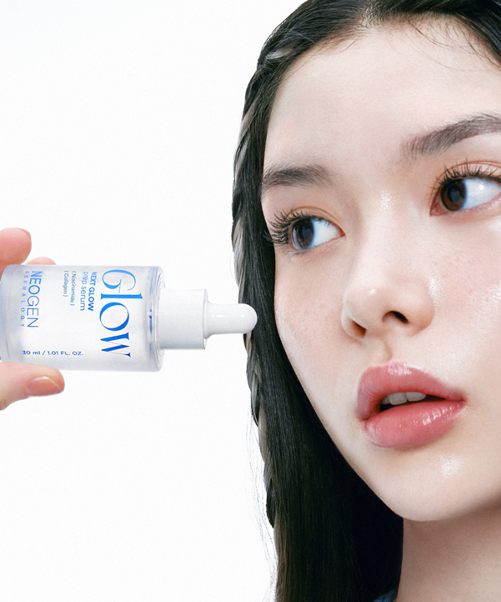 Woman applying NEOGEN Next Glow Prep Serum 32ml to face, highlighting radiant skin benefits.