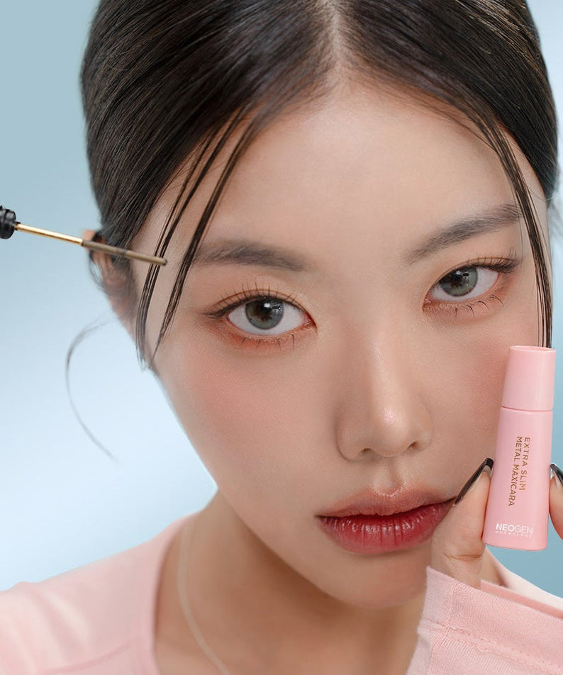 Woman applies NEOGEN Slim Metal Mascara 6ml for enhanced eyelashes, showcasing precise application.