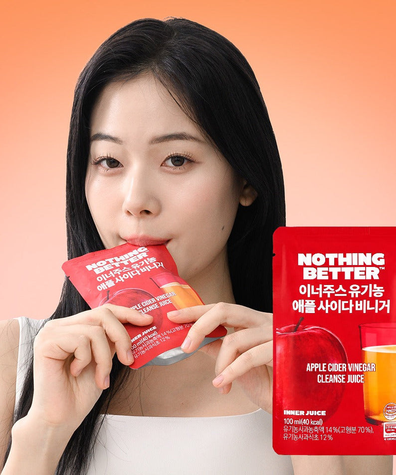 Woman sipping NOTHING BETTER Inner Juice Apple Cider Vinegar Cleanse Juice (X24) in red packaging, health and wellness product.