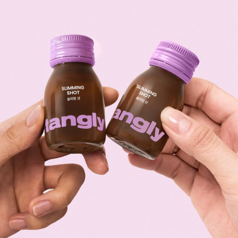 Hands holding two bottles of NOTHING BETTER Tangly Slimming Shot 7 Bottles against a pink background.