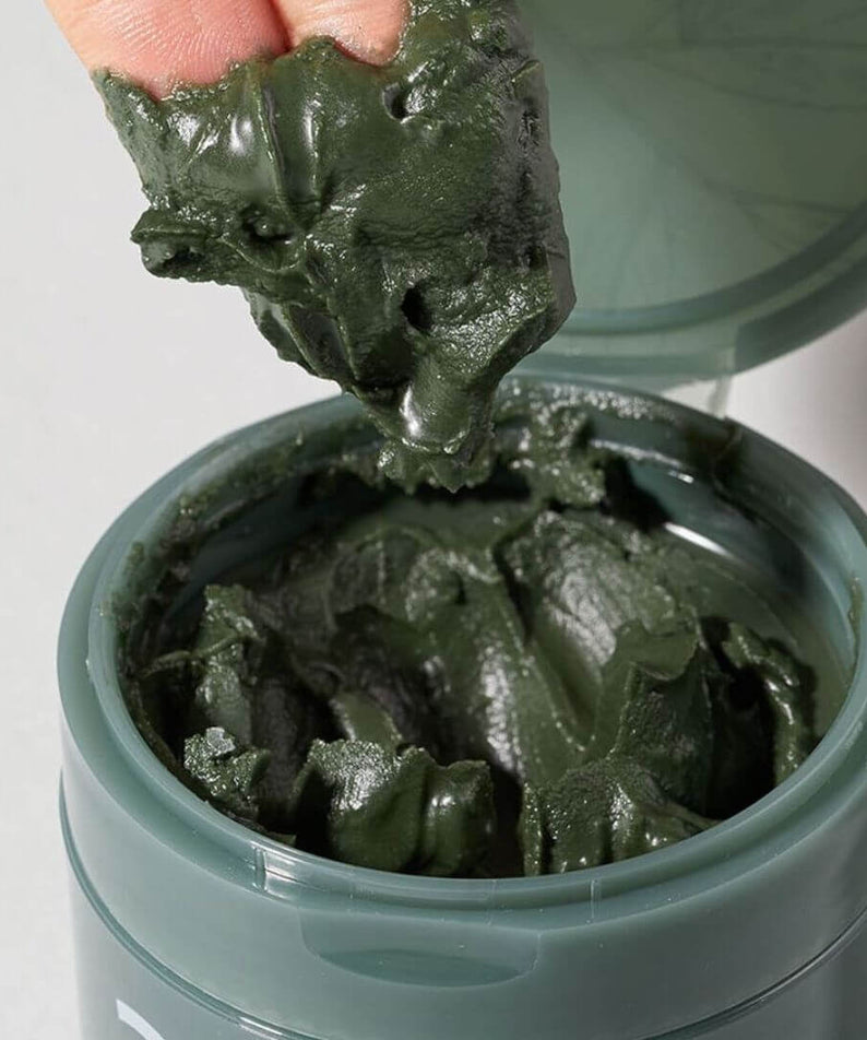 Open jar of NUMBUZIN No.3 Green Tea Charcoal Pore Pack Cleansing Balm with product texture being shown.