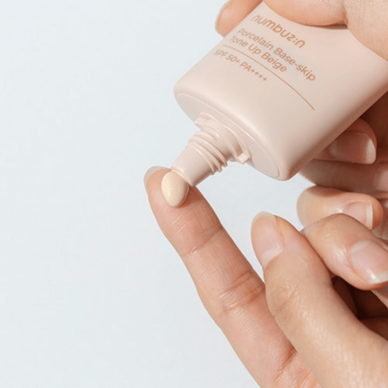 NUMBUZIN No.3 Porcelain Base-Skip Tone Up Beige SPF50+ PA++++ being applied to fingertip.