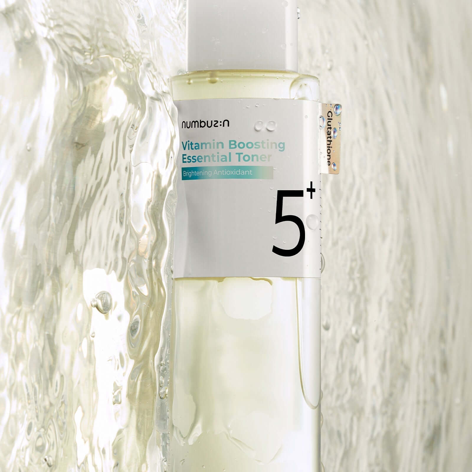NUMBUZIN No.5 Vitamin Boosting Essential Toner bottle close-up with water splashes, highlighting antioxidant-rich skincare product.