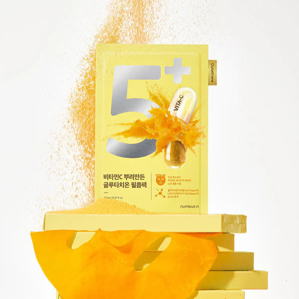 NUMBUZIN No.5 Vitamin Spotlight Sheets Mask packaging with a splash of vitamin C essence in the background.