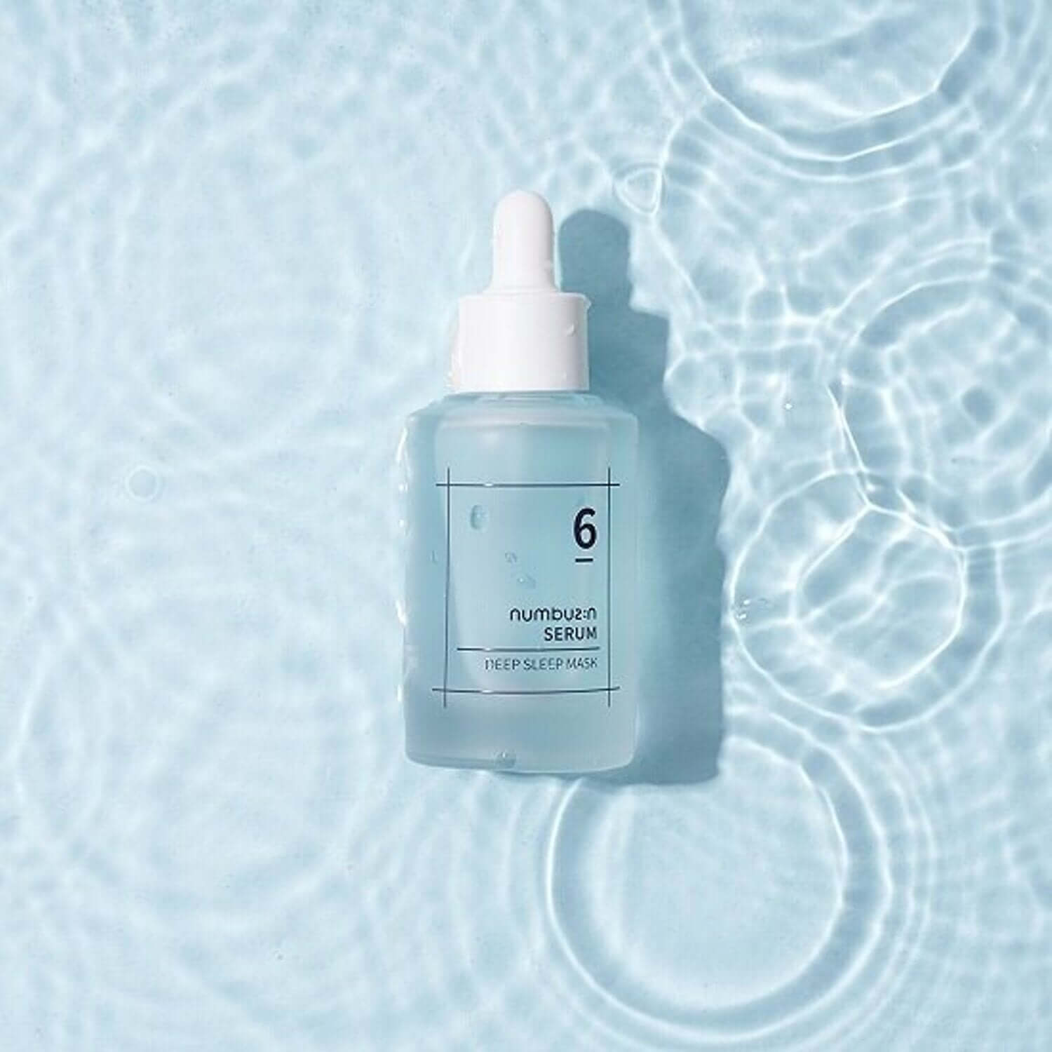 NUMBUZIN No.6 Deep Sleep Mask Serum bottle on rippled water surface, showcasing skincare packaging.