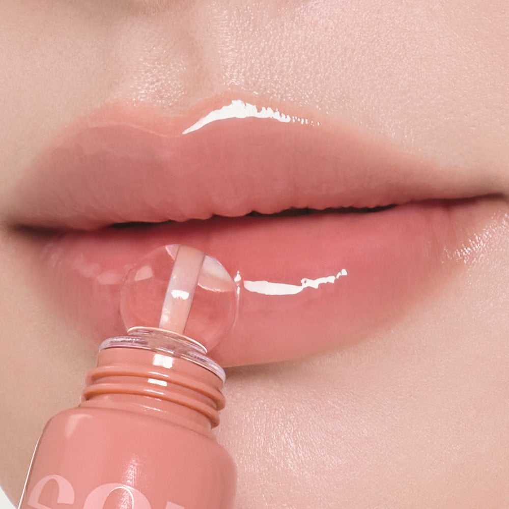 Close-up of lips applying NUSE Nuzzle Reju Lip Gloss, showcasing glossy finish.