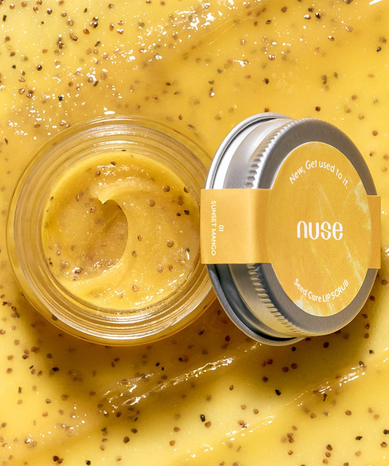 Open jar of NUSE Seed Care Lip Scrub surrounded by natural exfoliating seeds, showcasing the product's texture and ingredients.