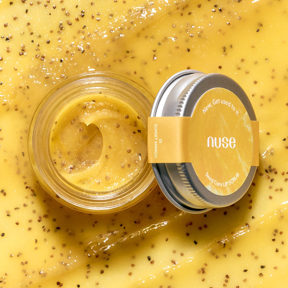 Open jar of NUSE Seed Care Lip Scrub surrounded by natural exfoliating seeds, showcasing the product's texture and ingredients.