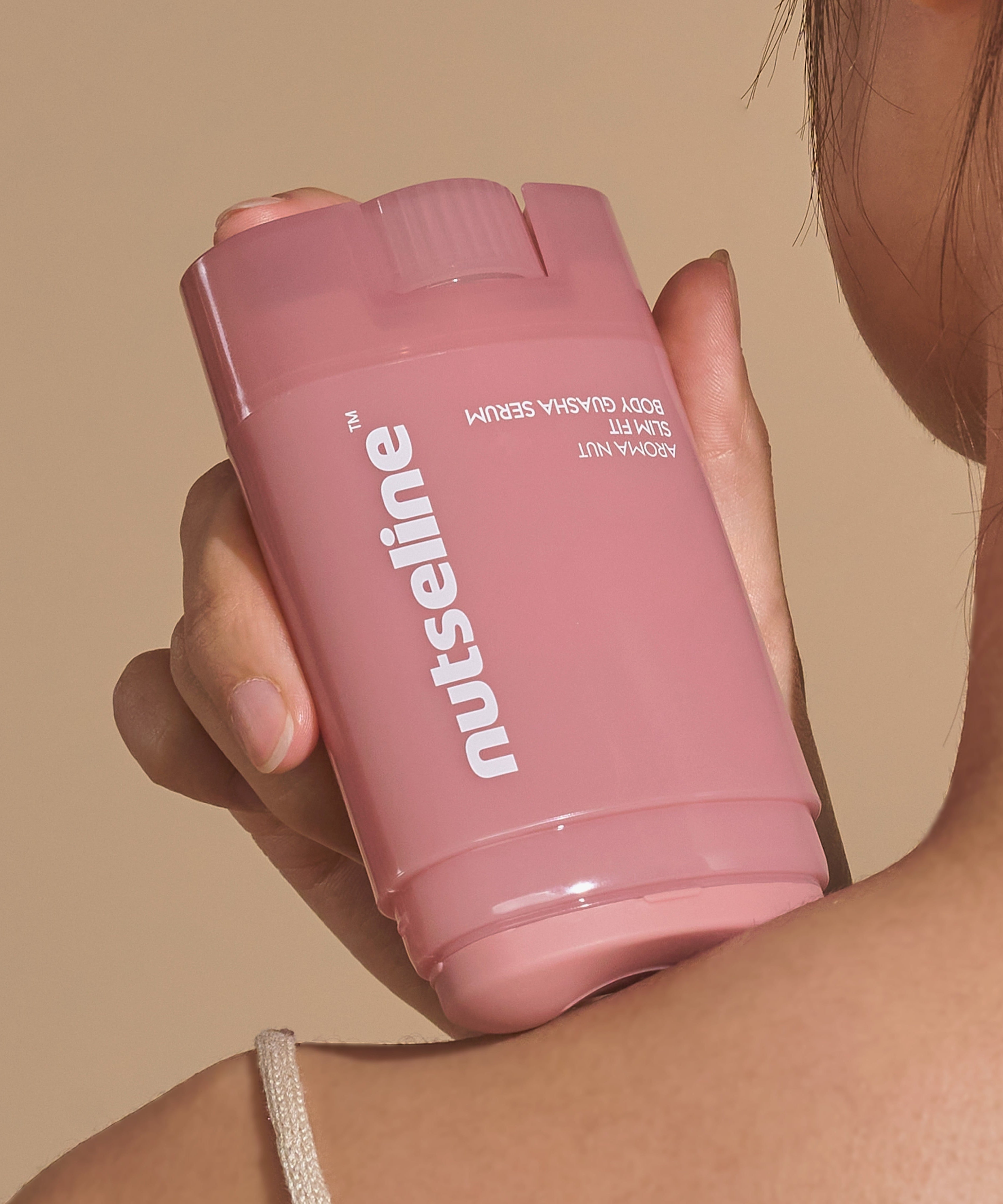 NUTSELINE Aroma Nut Slim Fit Body Guasha Serum 60ml bottle held by woman